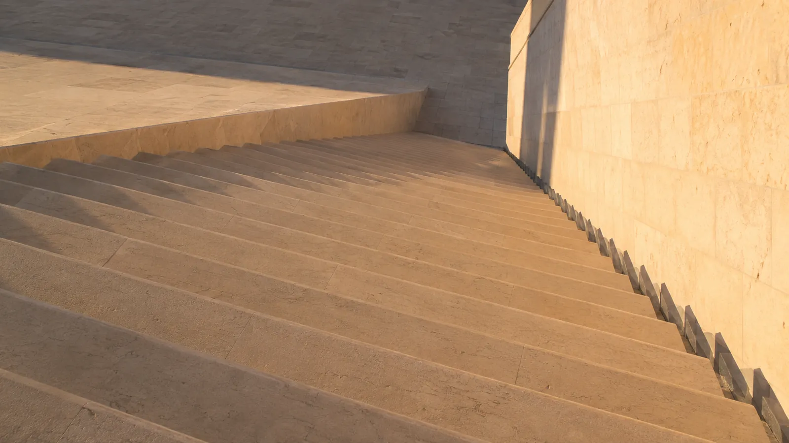 Late afternoon light raking across pale stone steps